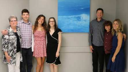 Nevin’s family are shown with the painting donated by Doug Freed. From left, Jean (wife), Jude and Josie (grandchildren) Denise (daughter), Kevin (son), Liam (grandson) and Suzanne (daughter-in-law)