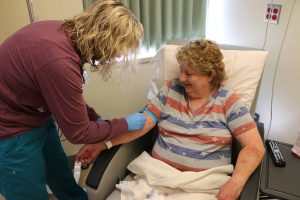Leslie Shapley, RN in the Bothwell Infusion & Procedure Center, preps Robbin McDonough to receive an IV line so she can receive her monthly medication to treat her rheumatoid arthritis symptoms.  